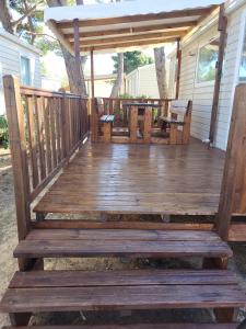 a wooden deck with a table and chairs on it at Mobil-home (Clim)- Camping Narbonne-Plage 4* - 019 in Narbonne-Plage