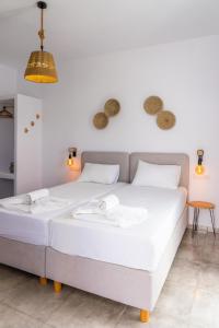 a white bed in a room with a white wall at Eleftheria Studios in Antiparos