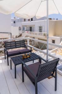 een groep tafels en stoelen op een balkon bij Eleftheria Studios in Antiparos Stad