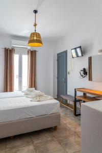 a bedroom with a bed and a table and a lamp at Eleftheria Studios in Antiparos
