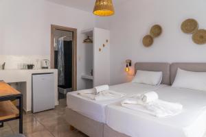 a bedroom with a white bed with towels on it at Eleftheria Studios in Antiparos