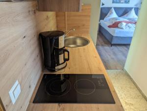 una piccola cucina con macchinetta del caffè su un bancone di Apartments Fischerklause am Bodensee a Wasserburg