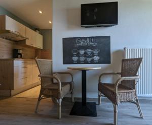 a table and chairs in a kitchen with a chalkboard at Apartments Fischerklause am Bodensee in Wasserburg am Bodensee
