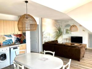 een keuken en een woonkamer met een tafel en een bank bij Grand appartement lumineux 4 pers. / vue mer / Wifi inclus in Quiberon