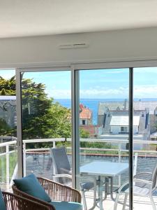 d'un balcon avec une table et des chaises et une vue sur l'océan. dans l'établissement Grand appartement lumineux 4 pers. / vue mer / Wifi inclus, à Quiberon