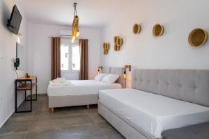 a bedroom with two beds and a couch at Eleftheria Studios in Antiparos