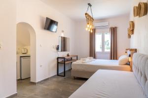 a hotel room with two beds and a couch at Eleftheria Studios in Antiparos