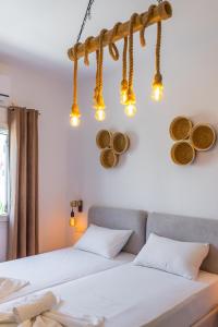 two beds in a bedroom with lights on the wall at Eleftheria Studios in Antiparos
