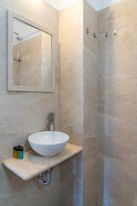 a bathroom with a white sink and a mirror at Eleftheria Studios in Antiparos
