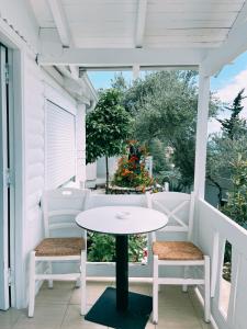 una mesa blanca y 2 sillas en un porche en ALEVRA, en Dhërmi