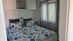 sypialnia z łóżkiem z niebiesko-białą pościelą i poduszkami w obiekcie Apartman Dado w mieście Cres