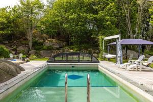een zwembad in een achtertuin met een prieel bij Spacious and fantastic villa with pool in beautiful Kullavik in Kullavik