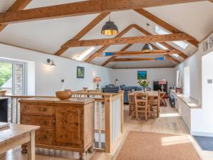 a kitchen and dining room with wooden beams at Swallows Barn in Totnes