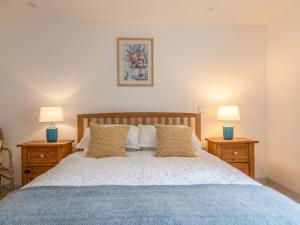 um quarto com uma cama grande e 2 mesas de cabeceira em Swallows Barn em Totnes