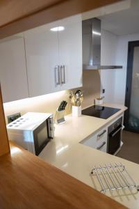 a kitchen with white cabinets and a counter top at Apartamentos Calpestabili in Altea