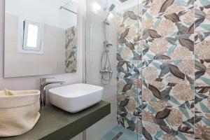 ein Bad mit einem Waschbecken und einem Spiegel in der Unterkunft Katerina Sea View Maisonette by Estia in Benitses