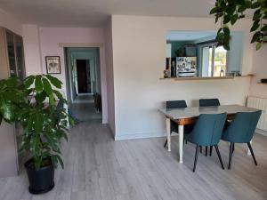a dining room with a wooden table and blue chairs at Lou beach home 75 m2 à 300 m de la plage avec vue mer in La Ciotat
