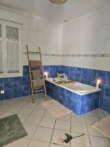 a blue and white bathroom with a tub and a ladder at Gite Le haut du Caraquet in Desvres