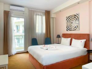 a hotel room with a bed with two shoes on it at City Plaza Apartments & Rooms in Thessaloniki