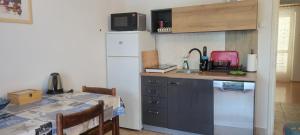 eine Küche mit einer Theke, einem Tisch und einem Waschbecken in der Unterkunft Apartmani Sonia in Njivice