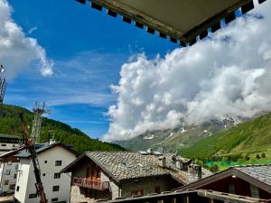 a view of a mountain with clouds in the sky at D'Hérens apartment in Breuil-Cervinia