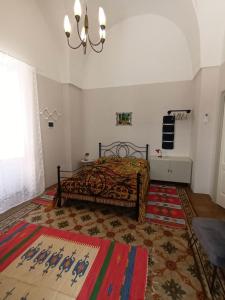 1 dormitorio con cama y lámpara de araña en Room in BB - Casa Dulcamara centro storico, en Salve