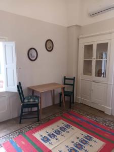 Cette chambre comprend une table, deux chaises et un tapis. dans l'établissement Room in BB - Casa Dulcamara centro storico, à Salve