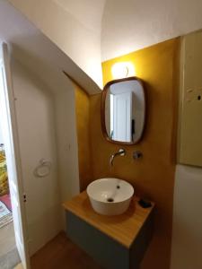 La salle de bains est pourvue d'un lavabo et d'un miroir. dans l'établissement Room in BB - Casa Dulcamara centro storico, à Salve