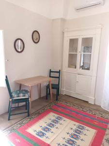 sala de estar con mesa, sillas y alfombra en Room in BB - Casa Dulcamara centro storico, en Salve