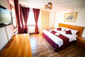 a hotel room with a bed and a television at Bliss Residence in Bucharest