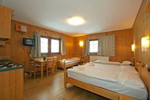 a bedroom with a large bed and a kitchen at Aalts Dorf in Riale