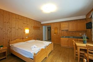a bedroom with a bed and a table and a kitchen at Aalts Dorf in Riale