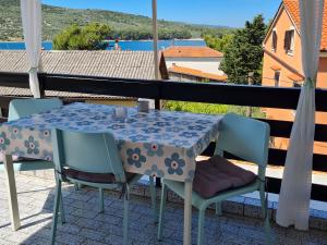 stół i krzesła na balkonie z widokiem w obiekcie Apartman Dado w mieście Cres