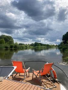 twee stoelen en een tafel op een boot op een rivier bij River Yacht Age of Aquarius in Poznań