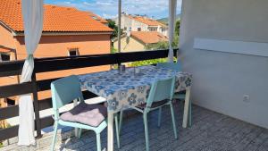 une table et des chaises assises sur un balcon dans l'établissement Apartman Dado, à Cres 8 autres photos