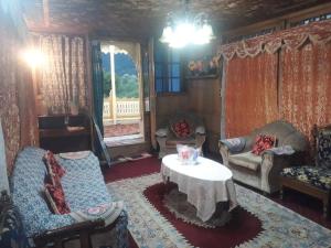 a living room with a couch and a table at Gulshan Group of HouseBoat in Srinagar
