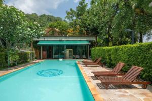 a swimming pool with chairs and a house at Villa Jacuzzi R6 The Height Khaoyai 1BR byน้องมังคุด in Ban Huai Sok Noi