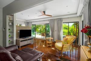 uma sala de estar com um sofá e uma televisão em Villa Jacuzzi R6 The Height Khaoyai 1BR byน้องมังคุด em Ban Huai Sok Noi