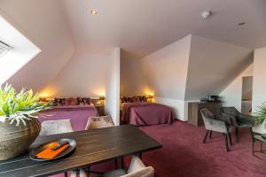 een kamer met twee bedden en een tafel en stoelen bij Hotel Bru in Bruinisse