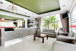 uma sala de estar com um sofá e uma mesa de centro em Sejati Hotel em Sitiawan