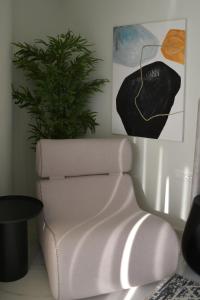 a white chair and a plant in a room at URBAN SUITES ATHENS in Athens