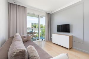 Televízia a/alebo spoločenská miestnosť v ubytovaní Green Square Apartments Świnoujście by Noclegi Renters