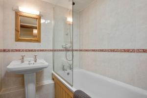 a bathroom with a sink and a toilet and a shower at The Coppermines Mountain Cottages - Sawyers, Millrace, Pelton Wheel, Sleeps 16 in Coniston