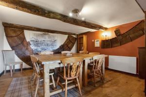 uma sala de jantar com uma mesa de madeira e cadeiras em The Coppermines Mountain Cottages - Sawyers, Millrace, Pelton Wheel, Sleeps 16 em Coniston