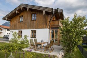 een huis met een tafel en stoelen ervoor bij Ferienhaus Naturzauber - Chiemgau Karte in Inzell