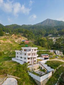 an aerial view of a white building on a hill at The White House Villa 8 bedroom with Swimming Pool in Kathmandu