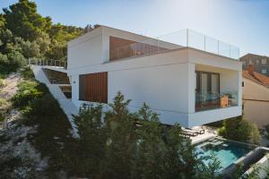 a house on a hill with a swimming pool at Villa Trinity - Hillside villa with Sea View and Infinity Pool in Kali