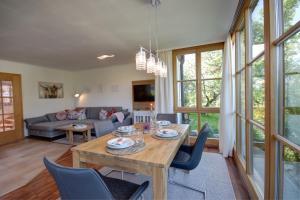 een woonkamer met een tafel en stoelen bij Ferienhaus Naturzauber - Chiemgau Karte in Inzell