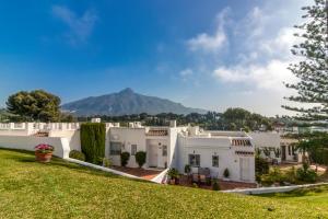 una fila de casas blancas con una montaña en el fondo en Azahara, Marbella en Marbella
