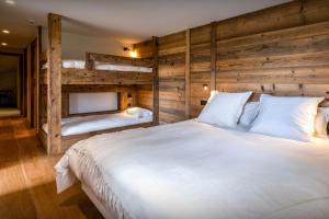 a bedroom with two bunk beds and a white bed at Chalet Arpitania - OVO Network in La Clusaz